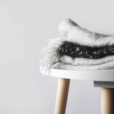 white and black textile on white and brown wooden seat