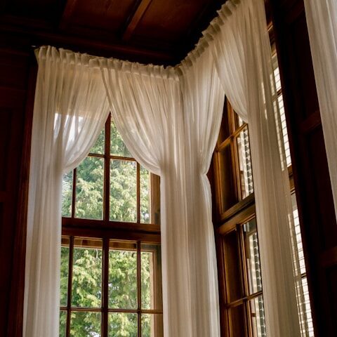 White curtains frame a bright window.