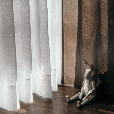 a stuffed animal sitting on the floor next to a window