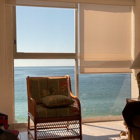 brown wooden framed padded armchair near window