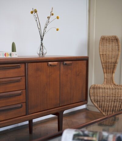 a wooden cabinet with a vase of flowers on top of it