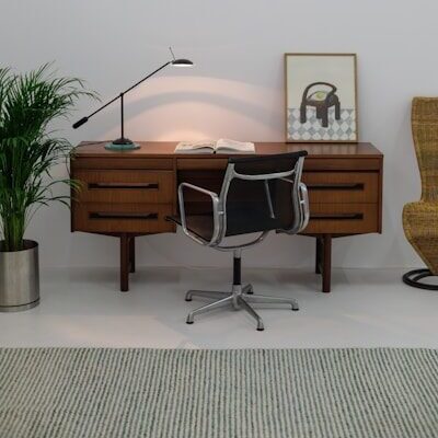 A room with a chair, desk and a lamp