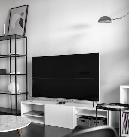 flat screen television on top of white wooden low-line TV stand