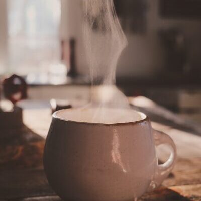 Steaming cup of coffee on a wooden table
